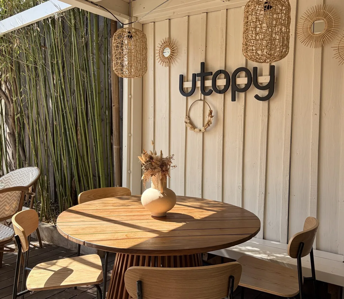 Terrasse d'UTOPY au Bouscat, enseigne en bois et mobilier en rotin